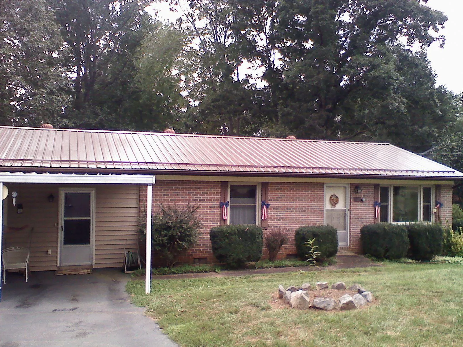 Bronze metal roof and carport on a brick ranch home — Roof Repair work by our crew in Longview